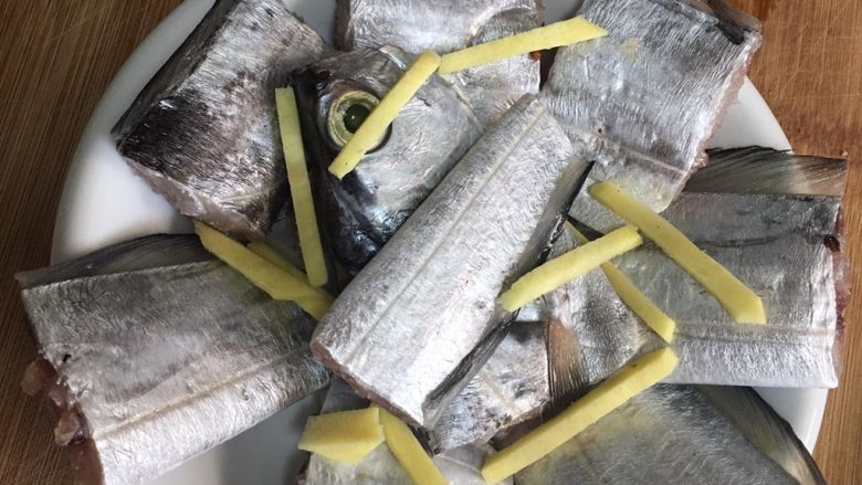 清蒸带鱼,腌制后洗干净,用餐纸控干水分,摆盘加姜丝及小葱白
