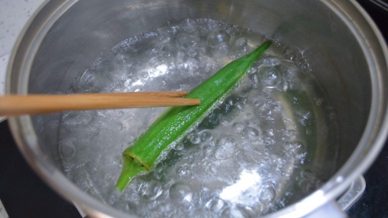 秋葵蒸蛋羹,水开后将秋葵整个放入沸水里焯水一分钟。焯水的时候秋葵是浮在水面的,要用筷子将秋葵翻滚一下。