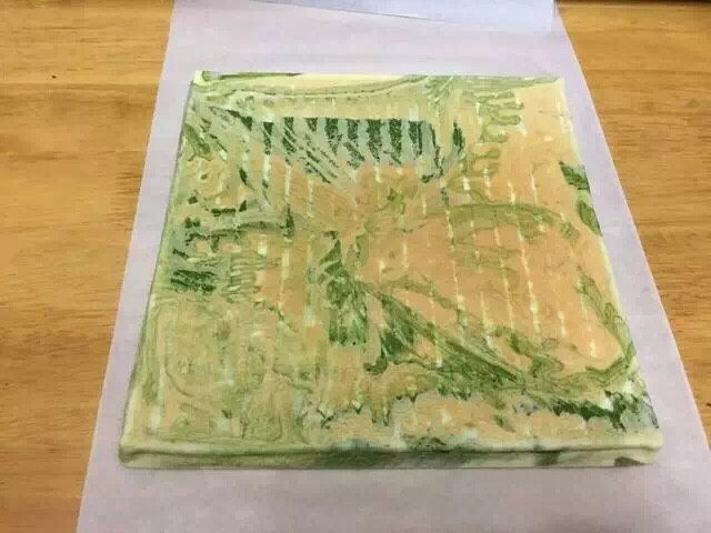 抹茶大理石浮云卷,蛋糕卷翻面,撕掉烘焙纸。
