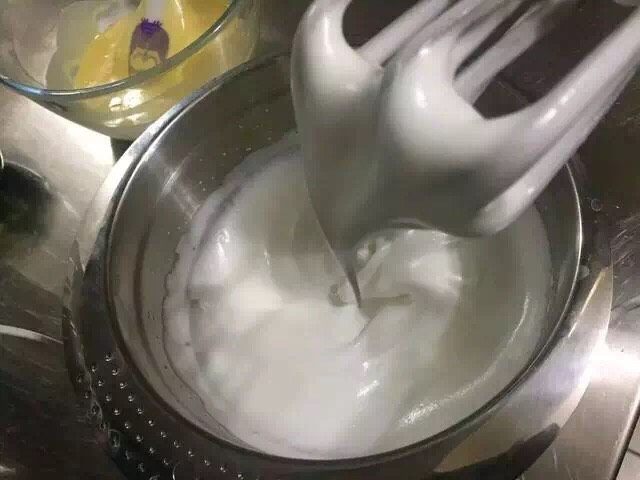 抹茶大理石浮云卷,继续搅打至蛋白霜稍微成型后,加入剩余的砂糖,再继续打发至湿性发泡,提起打蛋头有弯勾即可。