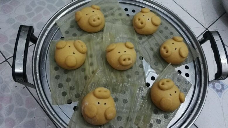 南瓜黄金招财猪馒头,蒸锅添温水,把小猪放上铺了玉米皮(也可用棉馏布、油纸等垫底防粘)的蒸架上,盖盖醒十五分钟左右。
