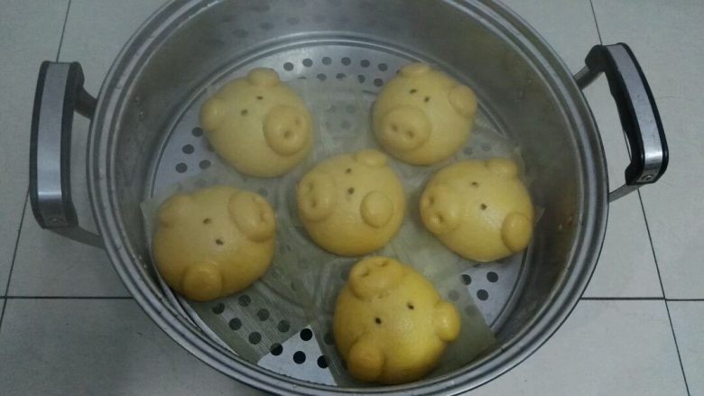 南瓜黄金招财猪馒头,第二层的小猪是不是更肥呢,因为放温水锅内二次醒发时它吸收的热量多才肥些,所以往锅内放生坯时,先做好的放上层,后做好的放下层,这样醒发状态差别