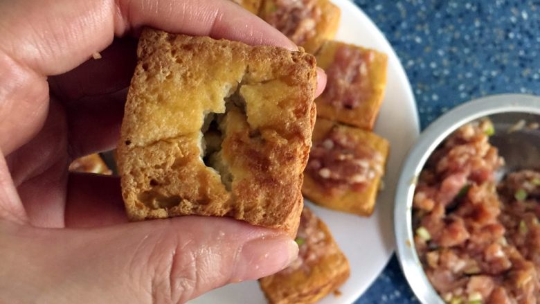 酿豆腐,拿一块豆腐，塞入肉。