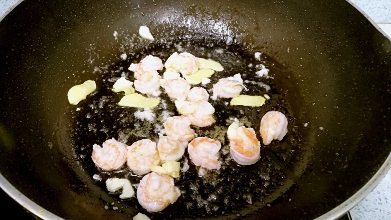 三珍炒虾球,锅里再倒一点油,爆香姜蒜,倒入虾仁,翻炒至成球状。