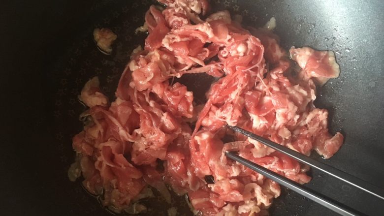 小牛饭便当,热锅凉油,下入肉卷,用筷子不停划拉,防止粘连,炒到全部变熟
