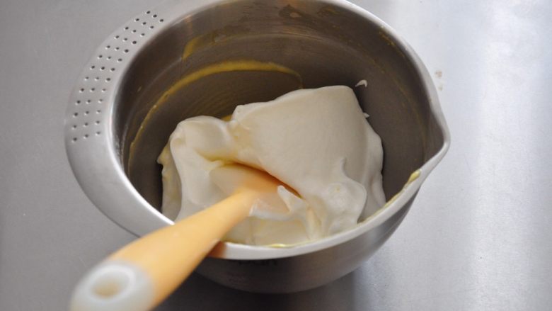 香缇奶油戚风蛋糕,取1/3的蛋白凉快入到蛋黄糊中。