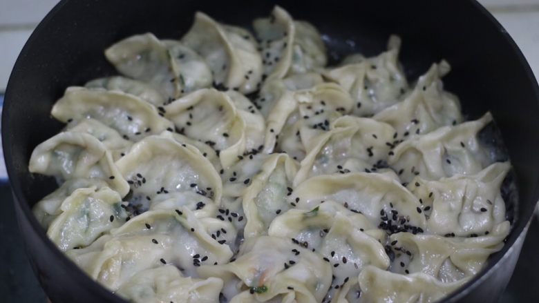 脆底煎饺(速冻饺子的救星),面粉水蒸发的差不多时候,可撒些<a style='color:red;display:inline-block;' href='/shicai/ 668'>黑芝麻</a>和葱花,增色增味(没有可省略),转小火加热,至水分完全蒸发,底部出现薄薄一层金黄色锅巴时,翻面