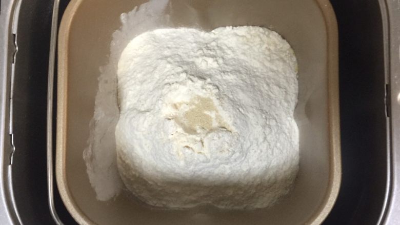 蔓越莓椰蓉千层吐司,面包机中加入高筋粉,盐,中间戳个洞,放上酵母粉。