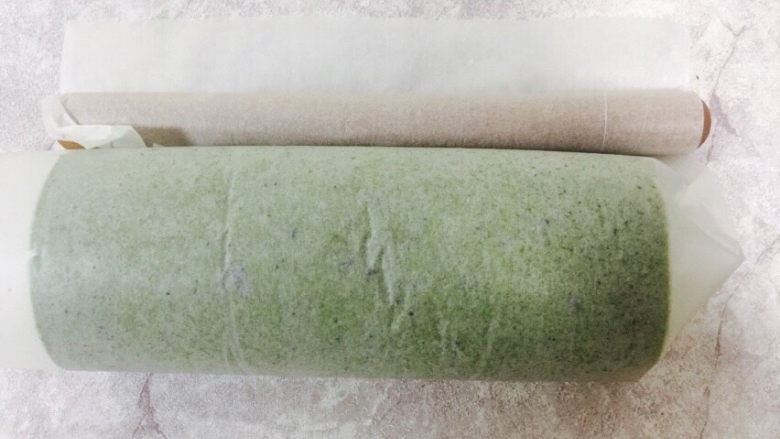 宇治抹茶卷,卷蛋糕卷的方法是:首先裁一张大点的烤纸,蛋糕胚放上。擀面杖在纸下的开位置,用手指头压住纸在擀面杖上往里收,收的同时蛋糕也慢慢卷起来。最后收尾如图,一定要收的时候用点力才能使你的蛋糕卷收得紧切的时候不会松