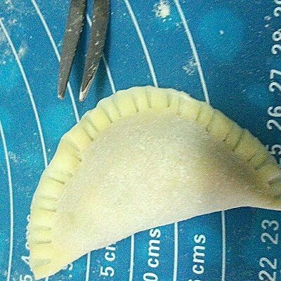 三鲜饺子,先用清水涂点在饺子边上,再合上,用小刀叉这样压花边。