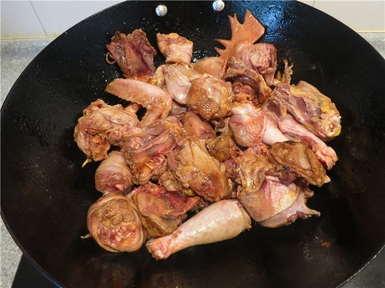 恩施高山小土豆炖鸡,当糖色变褐色起泡泡的时候将鸡块放入翻炒着色,动作要快