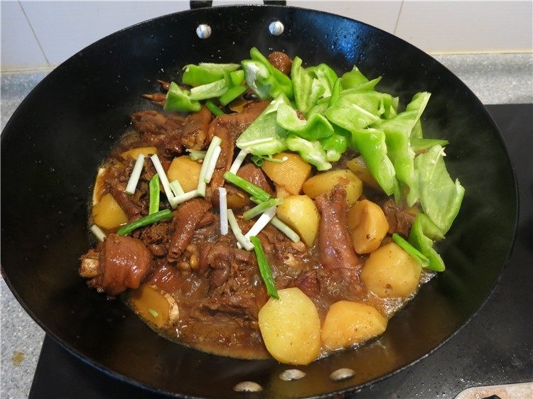恩施高山小土豆炖鸡,放入切好的辣椒片,放入<a style='color:red;display:inline-block;' href='/shicai/ 3232'>香葱</a>,开大火放入大蒜碎