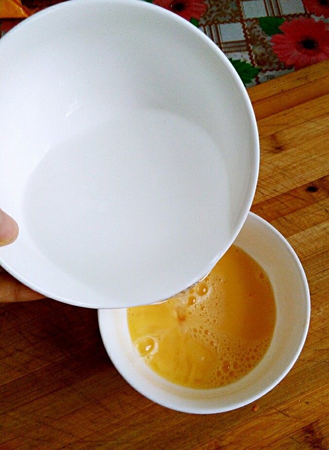 小葱鸡蛋羹,把温水倒进鸡蛋里,边倒边搅拌(我是因为要拍照,没有搅拌)