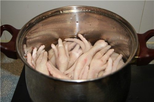 允指留香--香卤凤爪,将处理好的鸡爪子放入煮锅,加满水,水量以漫过鸡爪为宜
