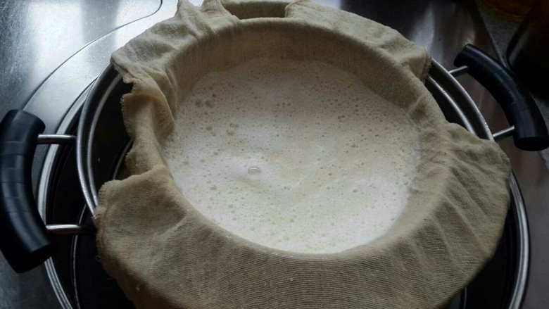 家庭自制豆腐，卫生又好吃,倒入过滤纱布过滤，挤压出豆浆（豆渣不要扔掉，可以烙饼也可以炒着吃很好吃的）