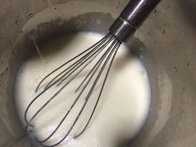 双皮奶-简约版,把已经降温的牛奶混合物倒入蛋白中,一边倒入一边用手动打蛋器搅拌,充分的让牛奶混合物与蛋白混合。