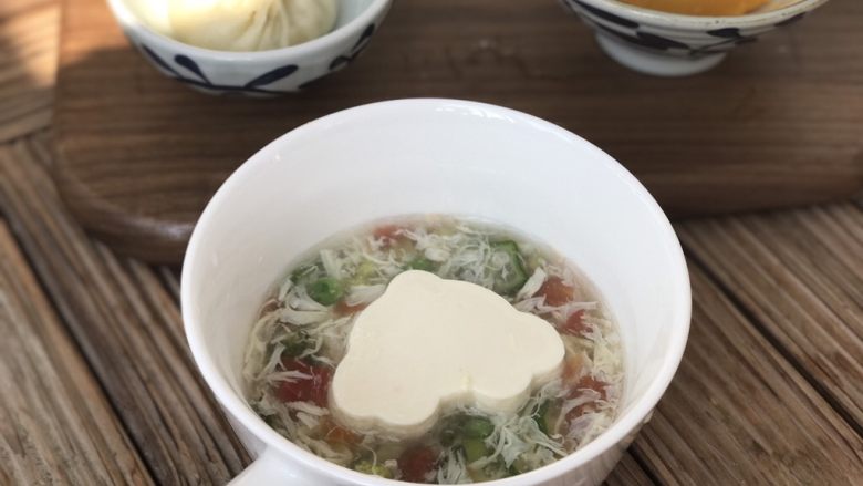 完美蛋花时蔬豆腐脑（宝宝辅食）,用模具刻出一块嫩豆腐放在碗里，浇上汤汁，再加入少许核桃油，或者亚麻籽油等坚果油，如果没有，加入芝麻油也是一样的。