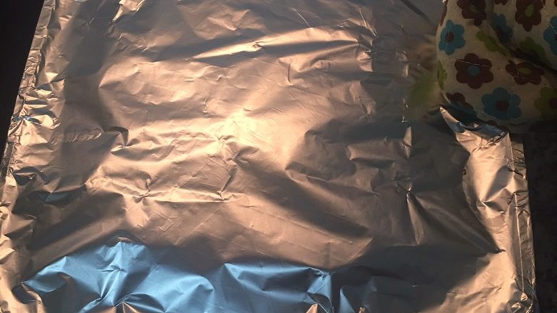 小茴香战斧猪排佐栉瓜丝,用铝箔纸(亮面朝下),盖住锅子,请注意锅子很烫,所以要带隔热手套再进行操作。
