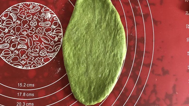 墨西哥抹茶蜜豆面包,取一个面团,压扁,擀成长舌状。