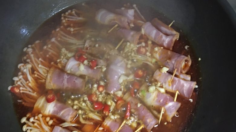 麻辣培根卷金针菇,将卷好的培根金针菇有序排列放入锅中 避免煮烂 中火焖制五分钟 大火收汁一分钟后盛出