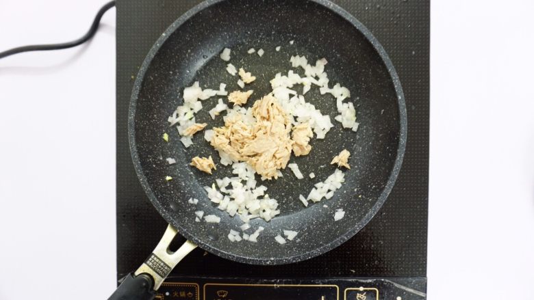 芝士片烤吞拿鱼饭团,倒入吞拿鱼翻炒几下,按个人口味加入适量盐,糖等调味,酱油可选。