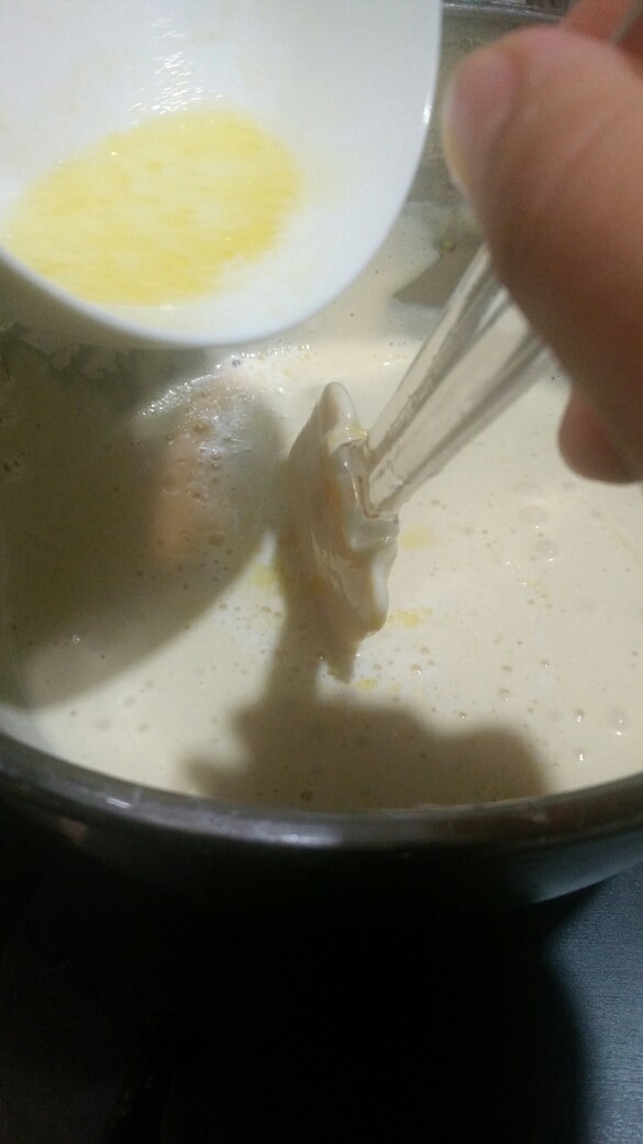 经典海绵蛋糕,融化好的牛奶和黄油液体,顺着刮刀撒在面糊周围,来回搅拌均匀即可。
