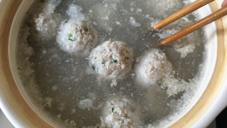 清炖狮子头,狮子头全部做好后,盖上盖子开中火,待开锅后转小火,这时狮子头已经定型,有些硬度,可以用筷子轻推底部,以免底部的狮子头粘锅