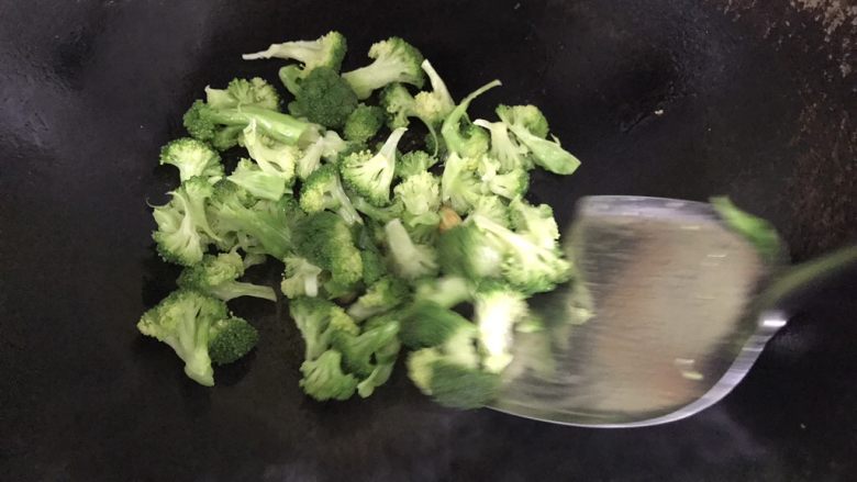 西蓝花炒鸡蛋火腿,锅中用热油爆香蒜头,加入西蓝花翻炒