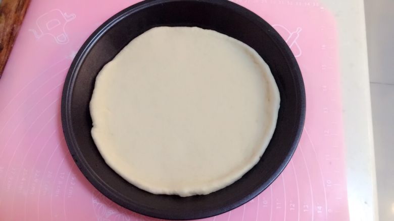 火腿披萨,把擀好的面饼放在抹好油的披萨盘里