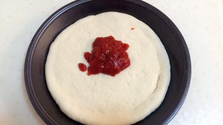 火腿披萨,在面饼上挤上适量的披萨酱