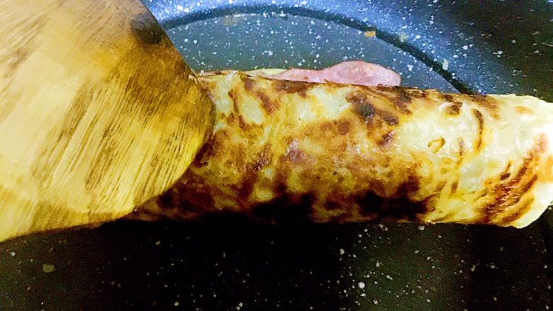 手抓饼版培根鸡蛋饼,直至卷成卷,整个制作过程全程开中小火
以免饼煎焦掉