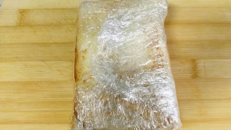 三明治,不管用什么办法,只要压实裹紧三明治。看看我裹的是不是像一个粽子,结结实实的?这样做主要是为了方便切半。