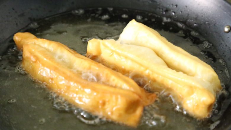 自制健康蓬松油条,油条会慢慢变大,呈现金黄色即可捞出。