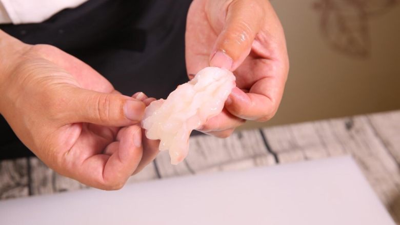 粗粮金汤明虾粥,3刀将虾尾,分成四片,这样第一个好处是容易入味,第二个好处是容易成型。翻卷之后好似一朵花。