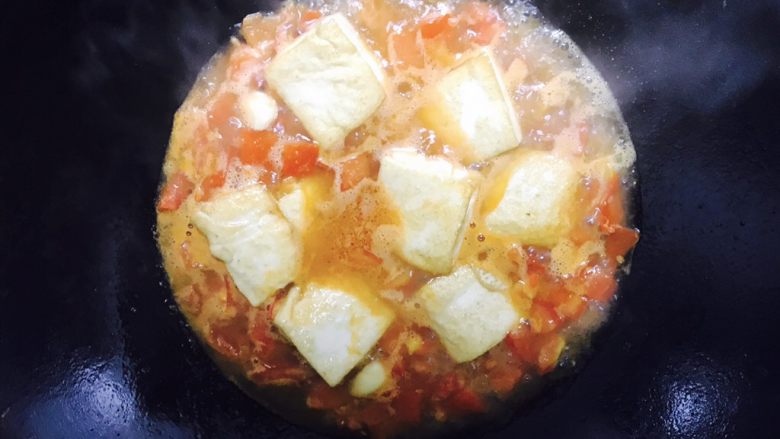 番茄豆腐焖猪肉,倒入豆腐块,铺好,放入适量的盐和糖,用中火焖,记得尝一下汁水的味道是否合适