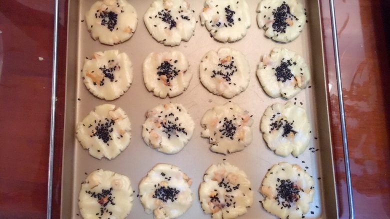 核桃酥,表面撒上少许芝麻，烤箱提前预热180度烤20分钟左右