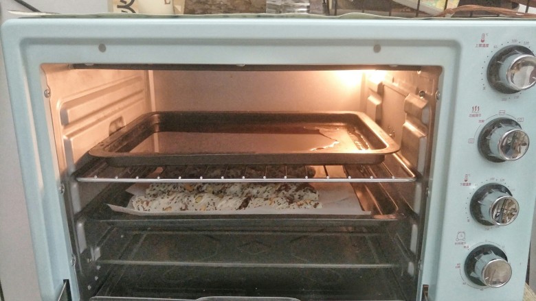 法式坚果面包棒,面团放入烤箱最底层,上面烤盘倒入少量的开水,调烤箱的发酵键50分钟进行第二次发酵