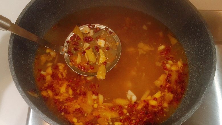 极品酸汤肥牛,煮开后,用筛子把姜、蒜、碎泡椒、花椒筛出;