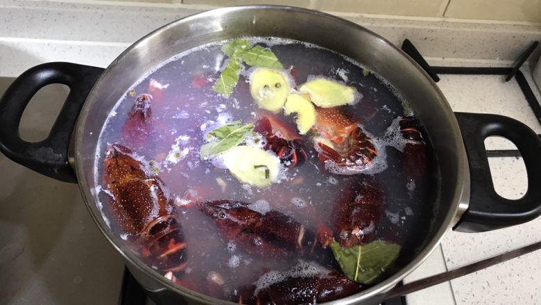 麻辣小龙虾 家常版,烧一锅水,水开后放入生姜片香叶,再放入清洗干净的小龙虾和钳子,放一点料酒或是白酒去腥。水再次开了以后关火捞起小龙虾。
