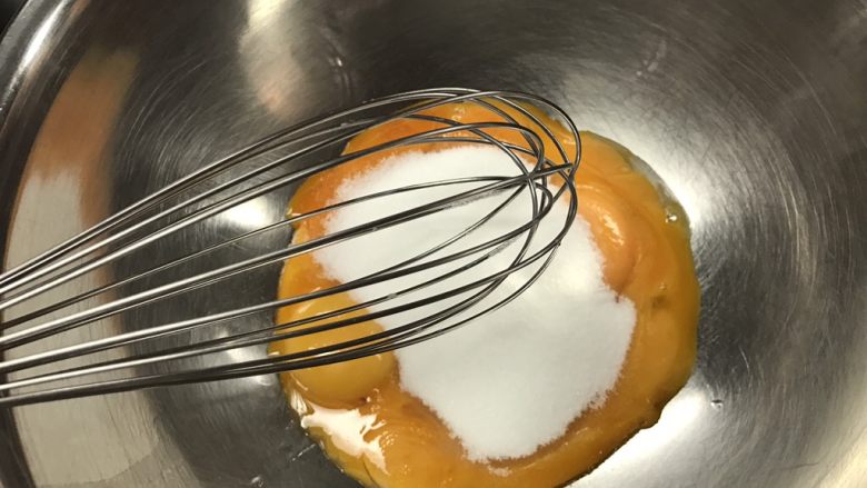 法式水果挞 Fruit Flan,蛋黄加入白糖,白糖不能一开始就和蛋黄放一起,因为白糖会吸水,如果和蛋黄放一起放5分钟以上,就会开始慢慢吸收蛋黄里面的水分,开始“煮”蛋黄,就跟平时我们腌渍的道理一样。所以蛋黄加了糖之后就要马上搅拌!