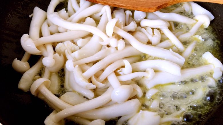 五彩腐竹,油热后倒入沥干水份的白玉菇,大火翻炒至白玉菇体积缩小,锅内有汤汁渗出