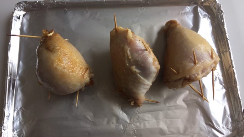 鸡腿包饭,烤盘铺上锡纸,将鸡腿放入烤盘中