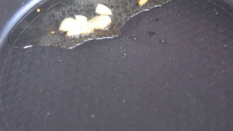 巨无霸带鱼翅根焖锅,锅里倒入油,放入蒜粒炸香。