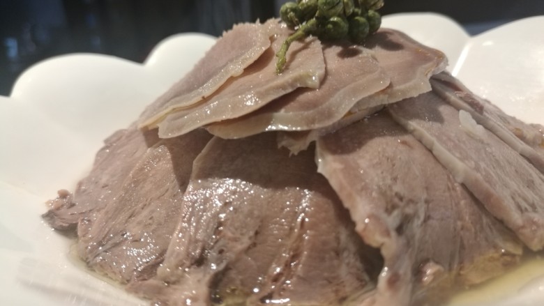 青藤椒口条,冷却后改刀切片后摆盘,放入少许原汤汁,滴上藤椒油