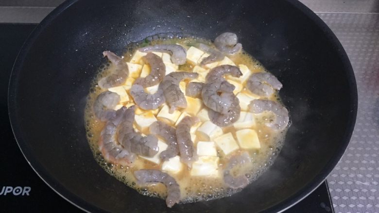 鲜虾豆腐煲,倒入虾,小心翻炒均匀