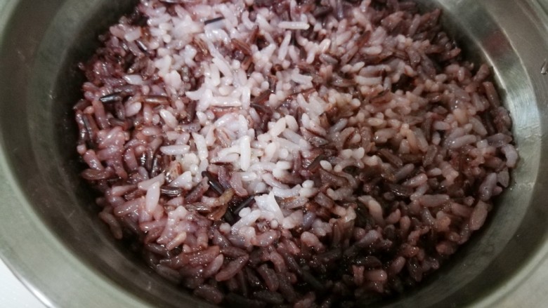 塑身益智三文鱼紫菜饭卷,出门前,将黑米白米洗净,水米比例1:1,并加入几滴油,放入定时高压锅中设定好时间,晚上到家,米粒颗颗晶莹的杂粮米饭已经炖好了。将杂粮米饭到入炒好的杂蔬三文鱼中拌匀。