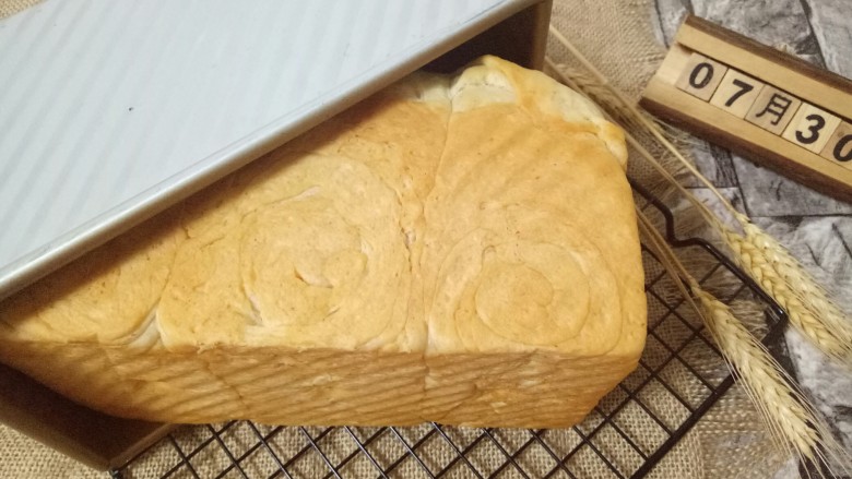 蔓越莓吐司面包,戴上隔热手套取出磨具,立即刷上一层玉米油,这样会更好的锁住面包的水份。