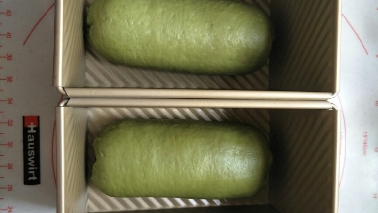 西瓜土司,按照西瓜🍉的原理,红曲面团最先擀饼上面撒一层熟红豆粒。依次包上白色面团最后包抹茶面团。放入模具进行发酵。