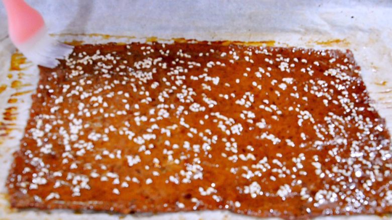 蜜汁黑椒肉脯,15分钟烤好后取出烤盘,将烤盘里的水倒掉,给肉片正面刷一层蜂蜜水。