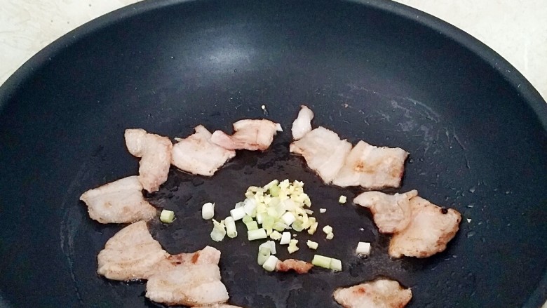 五花肉煸秋葵,煸炒出油,把五花肉扒拉到四周放入葱姜呛出味。